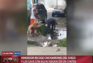 Vendedor recoge chicharrones del suelo y los lava con aguas negras de un contén