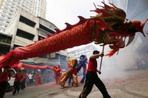 Bailarines en medio de petardos estallando durante una celebración del Año Nuevo Lunar chino. (AP )
