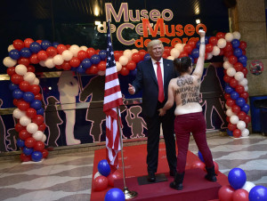 Una militante feminista agarra por la entrepierna una estatua de Trump en Madrid
