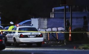 Operarios retiran el cuerpo de un fallecido mientras la policía trabaja en el escenario de una balacera en el club nocturno Cameo, el 26 de marzo de 2017, en Cincinnati. (AP Foto/John Minchillo)