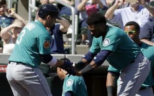 El dominicano Robinson Canó, de los Marineros de Seattle, felicita a su compañero Mike Zunino, quien conectó un jonrón en un duelo de pretemporada ante los Rockies de Colorado, el sábado 4 de marzo de 2017 (AP Foto/Chris Carlson)
