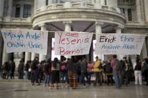 Papeles que muestran los nombres de las 40 niñas que murieron en un incendio en un albergue de Guatemala cuelgan a las afueras del Palacio de Bellas Artes, en Ciudad de México, mientras una docena de personas se reúne a protestar el lunes 13 de marzo de 2017. Autoridades de Guatemala arrestaron a tres funcionarios de la secretaría que tenía a su cargo el hogar y el bienestar de las menores. (AP Foto/Rebecca Blackwell)