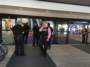 Unos policías aparecen en la entrada de una terminal en el Aeropuerto Internacional Bishop, el miércoles 21 de junio del 2017 en Flint, Michigan. El aeropuerto Bishop fue evacuado el miércoles luego de que un testigo dijo que vio a un policía sangrando del cuello y un cuchillo cerca del piso. (Dominic Adams/The Flint Journal-MLive.com via AP)