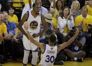 Kevin Durant (35) de los Warriors de Golden State celebra con Stephen Curry (30) durante el segundo partido de la final de la NBA ante los Cavaliers de Cleveland, el domingo 4 de junio de 2017. (AP Foto/Marcio José Sánchez)