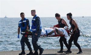 En esta imagen, distribuida por el Ministerio de Defensa de Japón, un miembro de la tripulación del USS Fitzgerald que resultó herido es trasladado por personal militar estadounidense  (izquierda) y miembros de la fuerza de autodefensa marítima de Japón a su llegada a una base naval estadounidense en Yokosuka, al suroeste de Tokio, tras una colisión entre el destructor y un buque mercante con bandera de Filipinas, ACX Crystal, en aguas de la península de Izu, el 17 de junio de 2017. (Ministerio de Defensa de Japón via AP)