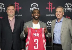 Chris Paul, centro, posa con su camiseta al ser presentado como nuevo integrante de los Rockets de Houston por el gerente general Daryl Morey, izquierda, y el entrenador Mike D'Antoni, durante una conferencia de prensa el viernes 14 de julio de 2017, en Houston. (AP Foto/David J. Phillip)