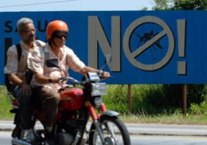 HAB04 LA HABANA (CUBA) 27/09/06 .- Dos hombres pasan junto a un cartel de campaña contra el Dengue, hoy miércoles 27 de septiembre, en Alamar. Desde hace semanas Cuba está volcada en una campaña en todo el país con movilizaciones masivas de trabajadores, estudiantes y profesionales de la salud para conseguir atajar un brote de la enfermedad, de cuyo impacto sobre la población aún no se han divulgado cifras oficiales. EFE/Orlando Barría