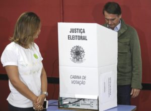GRAF6907 RIO DE JANEIRO (BRASIL), 28/10/18.-El candidato ultraderechista Jair Bolsonaro, acompañado de su esposa, Michelle, vota en una area militar en la zona norte de Río de Janeiro. Los colegios electorales de Brasil abrieron hoy para la segunda vuelta de las presidenciales, que enfrentan al ultraderechista Jair Bolsonaro, favorito en todas las encuestas, y al progresista Fernando Haddad. EFE/ Ricardo Moraes/POOL