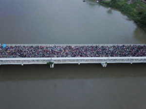 GUA04. TECÚN UMÁN (GUATEMALA), 19/10/2018.- Fotografía tomada desde un dron de los cientos de migrantes hondureños que permanecen varados en uno de los puentes que atraviesa el río Suchiate, frontera natural entre Guatemala y México hoy, viernes 19 de octubre de 2018, en Tecún Umán (Guatemala). Miles de migrantes de la caravana que partió el sábado pasado de Honduras forzaron hoy la valla fronteriza desde Guatemala e ingresaron a México, donde las fuerzas de seguridad se vieron en un primer momento rebasadas por un imparable río humano. Tras un primer momento de euforia, los migrantes fueron contenidos por la Policía Federal mexicana, lo que desencadenó momentos de tensión. EFE/Gabriela Ríos