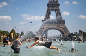 IAN53. PARÍS (FRANCIA), 25/06/2019.- Una mujer se refresca con el agua de la fuente de la Plaza del Trocadero, frente a la Torre Eiffel, durante la ola de calor que recorre París este martes (Francia). Las temperaturas llegarán a los 40 grados centígrados esta semana. EFE/Ian Langsdon