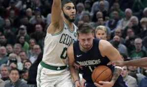 El jugador de Dallas Mavericks Luka Doncic, centro, es defendido por el jugador de Boston celtics Jayson Tatum (0) durante un partido de baloncesto de la NBA en Boston, el lunes 11 de noviembre del 2019. Los Celtics vencieron a los Mavericks 116-106.