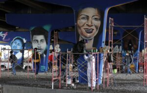 Artistas fueron registrados al pintar grafitis sobre las paredes de un puente, en memoria de las víctimas de la violencia policial, en Bogotá (Colombia). EFE/Mauricio Duenas Castañeda