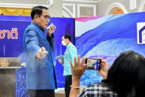 This handout from the Royal Thai Government taken and released on March 9, 2021 shows Thailand's Prime Minister Prayut Chan-O-Cha spraying hand sanitiser at journalists in an attempt to avoid questions about the cabinet reshuffle during a press conference in Bangkok. (Photo by Handout / ROYAL THAI  GOVERNMENT / AFP) / -----EDITORS NOTE --- RESTRICTED TO EDITORIAL USE - MANDATORY CREDIT 