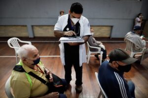Personal médico toma los datos a una persona en la sede del Partido Unace, en San Lorenzo (Paraguay). EFE/ Nathalia Aguilar/Archivo