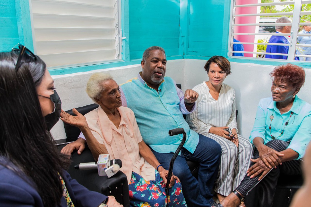 Tony Peña Guaba, en compañia de la representante del Banco Mundial, conversan con Doña Ramona en su vivienda de Monte Plata